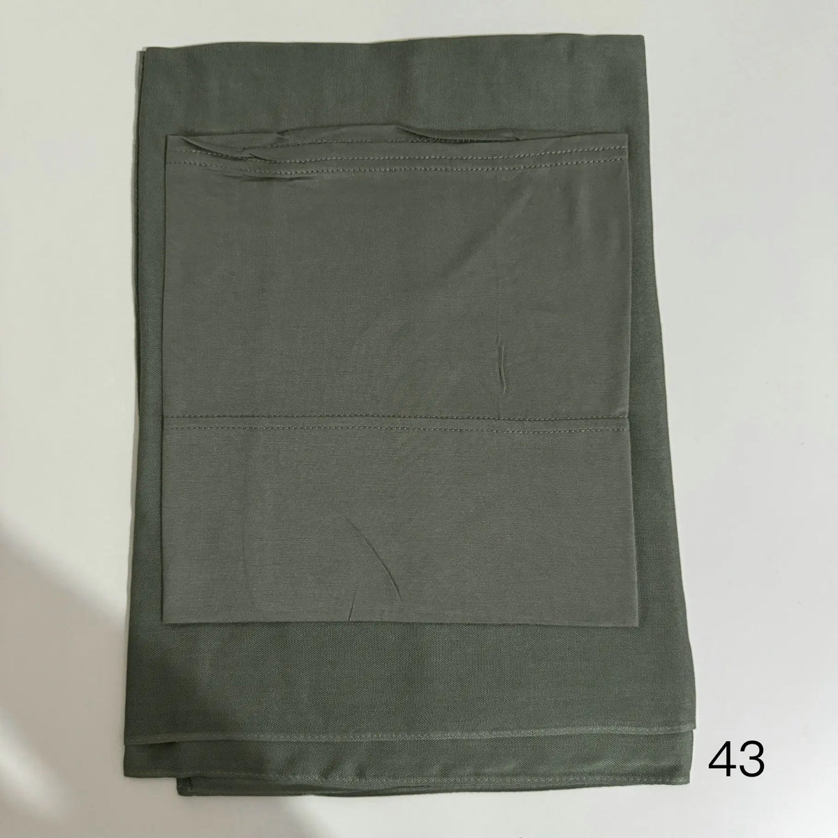 A solid olive green soft modal rayon hijab set folded neatly.