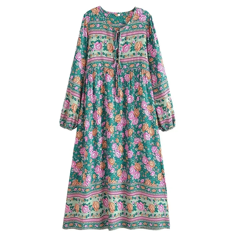 A long-sleeved floral maxi dress in teal green with pink and green patterns.