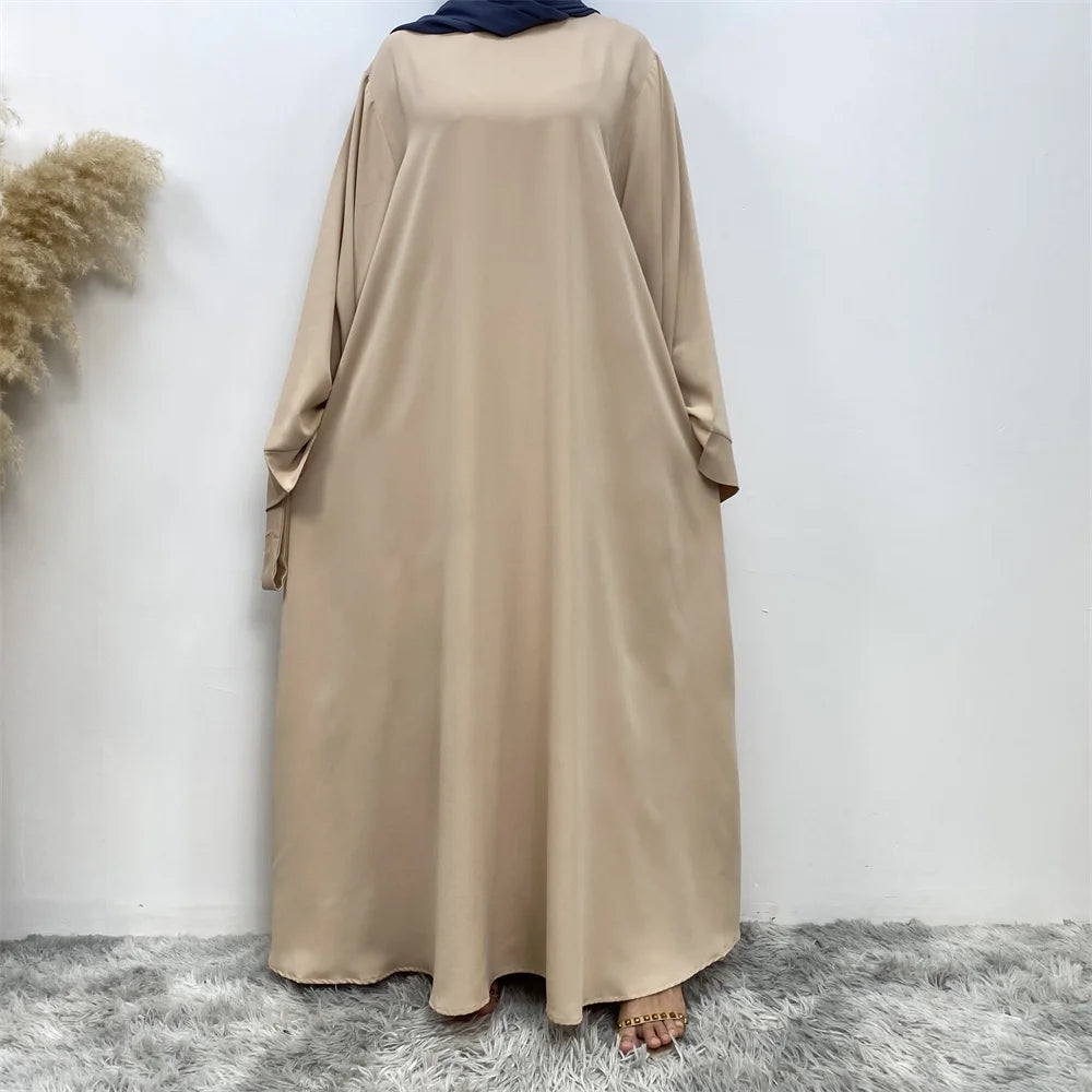 Ein langes beige Maxi-Abaya für Damen, präsentiert vor weißem Hintergrund.