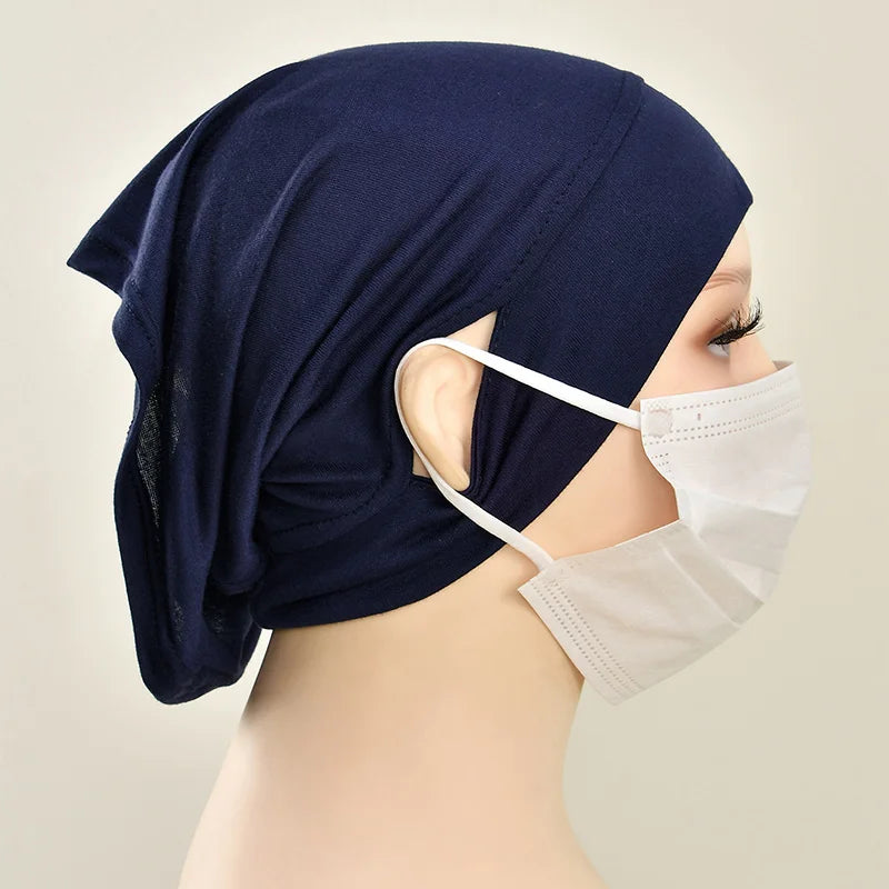 Marineblaue Baumwoll-Hijab-Kappe auf einem Mannequin, kombiniert mit einer weißen Schutzmaske.