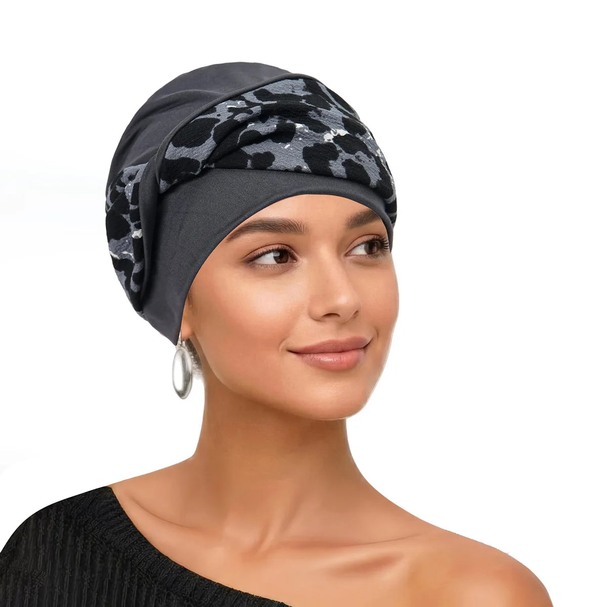 Eine Frau modelliert einen dunkelgrauen bedruckten Turban mit einem schwarzen Pullover.