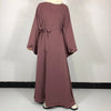 Une robe abaya mauve uni portée par un mannequin, avec un détail de ceinture nouée.