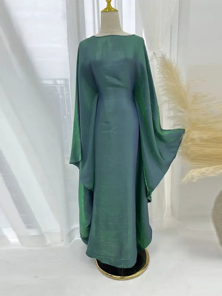 Una abaya de satén color verde azulado con corte batwing, exhibida en un maniquí.
