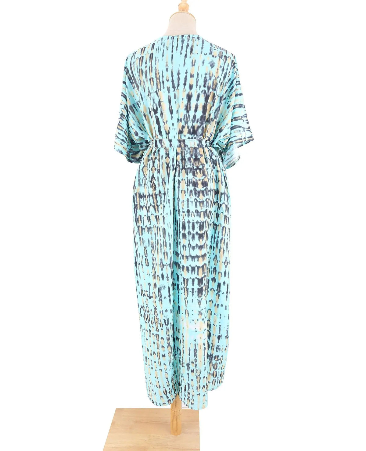 Eine Frau modelliert ein langes, fließendes Sommer-Strandkimono-Überkleid mit abstraktem blauem und beigem Muster.