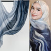 Eine Frau trägt einen aus Aquarell-Ombré gedruckten Rayon-Modal-Hijab-Schal mit blauen und grauen Wirbeln.