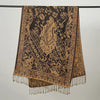 Pañuelo de pashmina marrón oscuro de lujo con intrincados bordados dorados colgado en una percha.