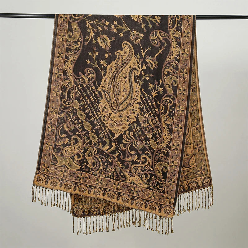 Pañuelo de pashmina marrón oscuro de lujo con intrincados bordados dorados colgado en una percha.