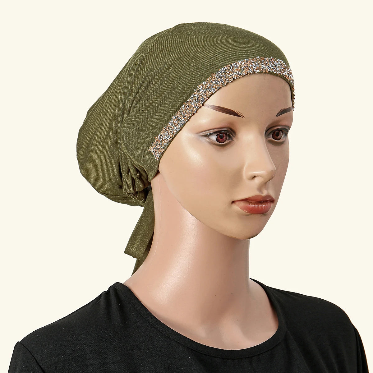 Ein Model trägt einen olivgrünen Hijab mit Strassverzierung und einem schwarzen Oberteil.