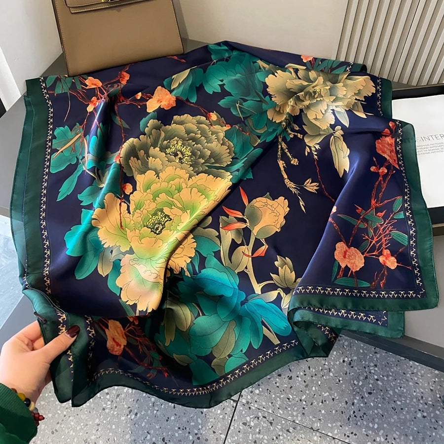 Dunkelblaue Seidsscarf mit lebendigem Blumen- und Blattmuster und goldenen Akzenten.