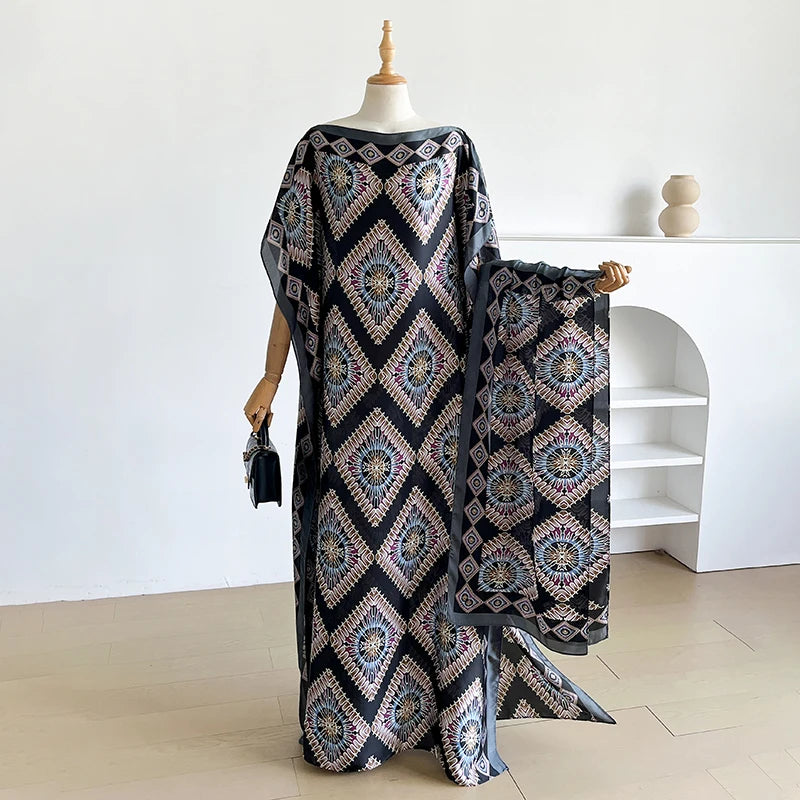 Schwarzes Kaftankleid mit aufwendiger geometrischer Stickerei und passender Schal auf einem Mannequin.