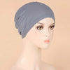 A model wears a solid gray stretch jersey turban cap on her head.