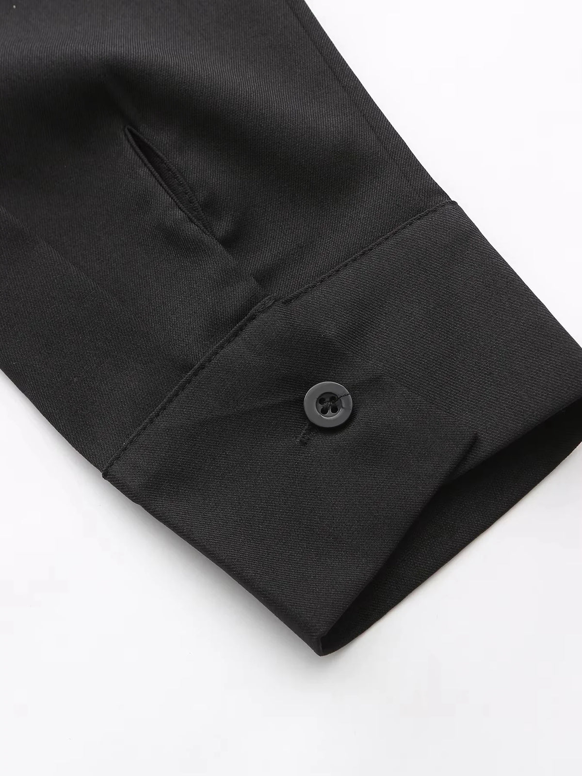 Man's black Muslim robe sleeve showing a button closure and retro embroidery detail.