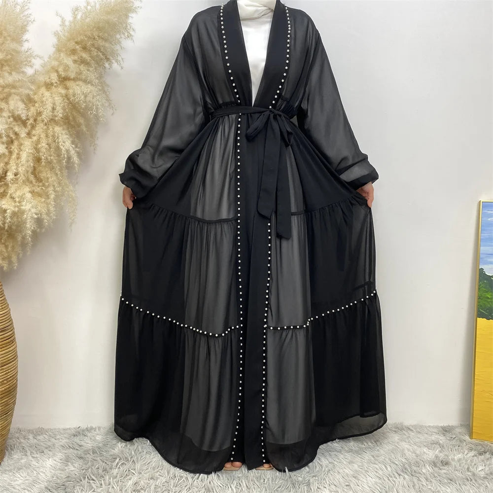 Una elegante bata cardigan abaya negra con detalles de cuentas, mostrada contra un fondo blanco.