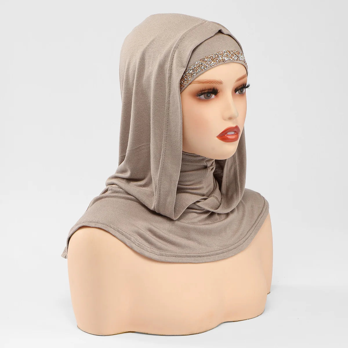 Un modèle porte un bonnet hijab instant double couche beige avec une bordure dorée scintillante.