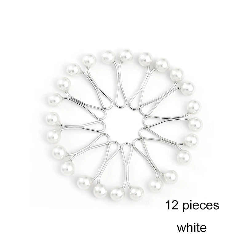 A circular arrangement of twelve silver pearl brooch headscarf pins.