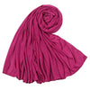 Un foulard hijab en jersey de coton magenta profond roulé en spirale décorative.