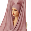 Ein Modell trägt ein staubrosa Modal-Jersey-Hijab, elegant um ihren Gesicht drapiert.