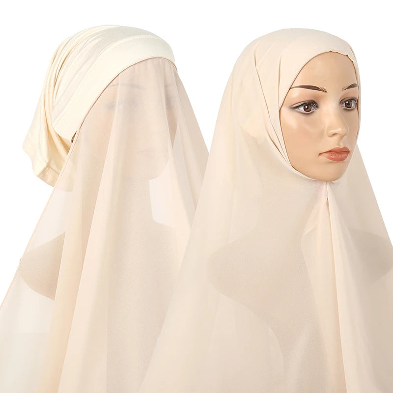 A woman wearing a light beige chiffon instant hijab with a modal cotton cap.