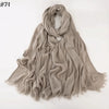 Un foulard hijab en coton viscose beige doux, drapé et plié sur un fond blanc.
