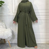 A full-length olive green abaya and kaftan set worn by a model in a bright room.