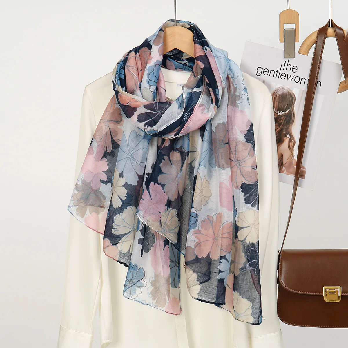 Fließender Blumen-Viskose-Schal in Blau-, Rosa- und Grautönen, drapiert um einen weißen Blazer.