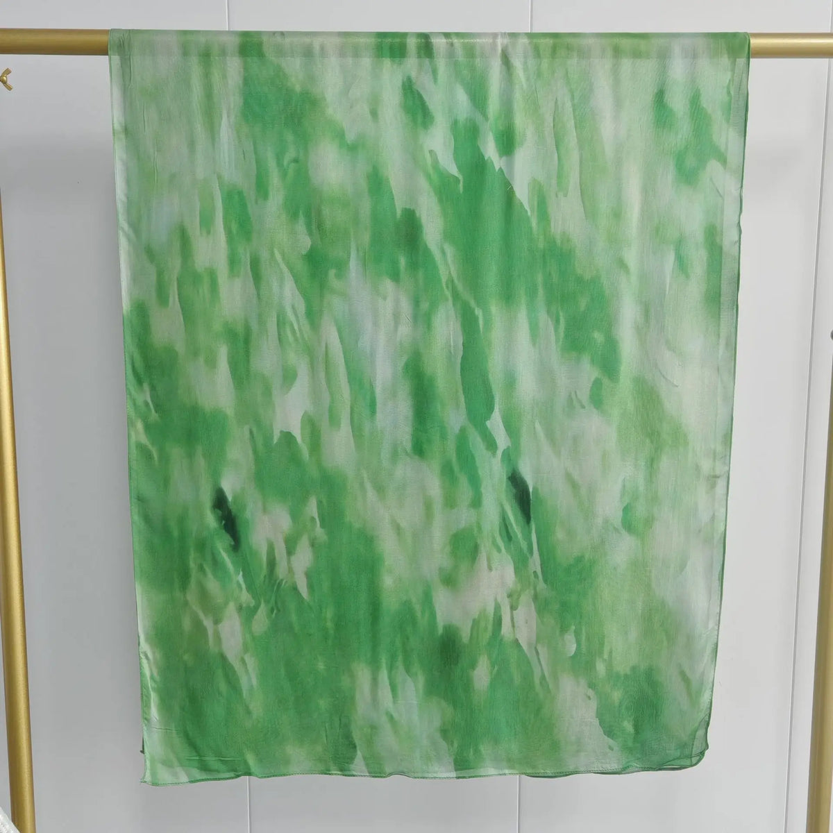 Vertikaler grün-weißes Aquarell-Tie-Dye-Schal vor hellem Hintergrund.