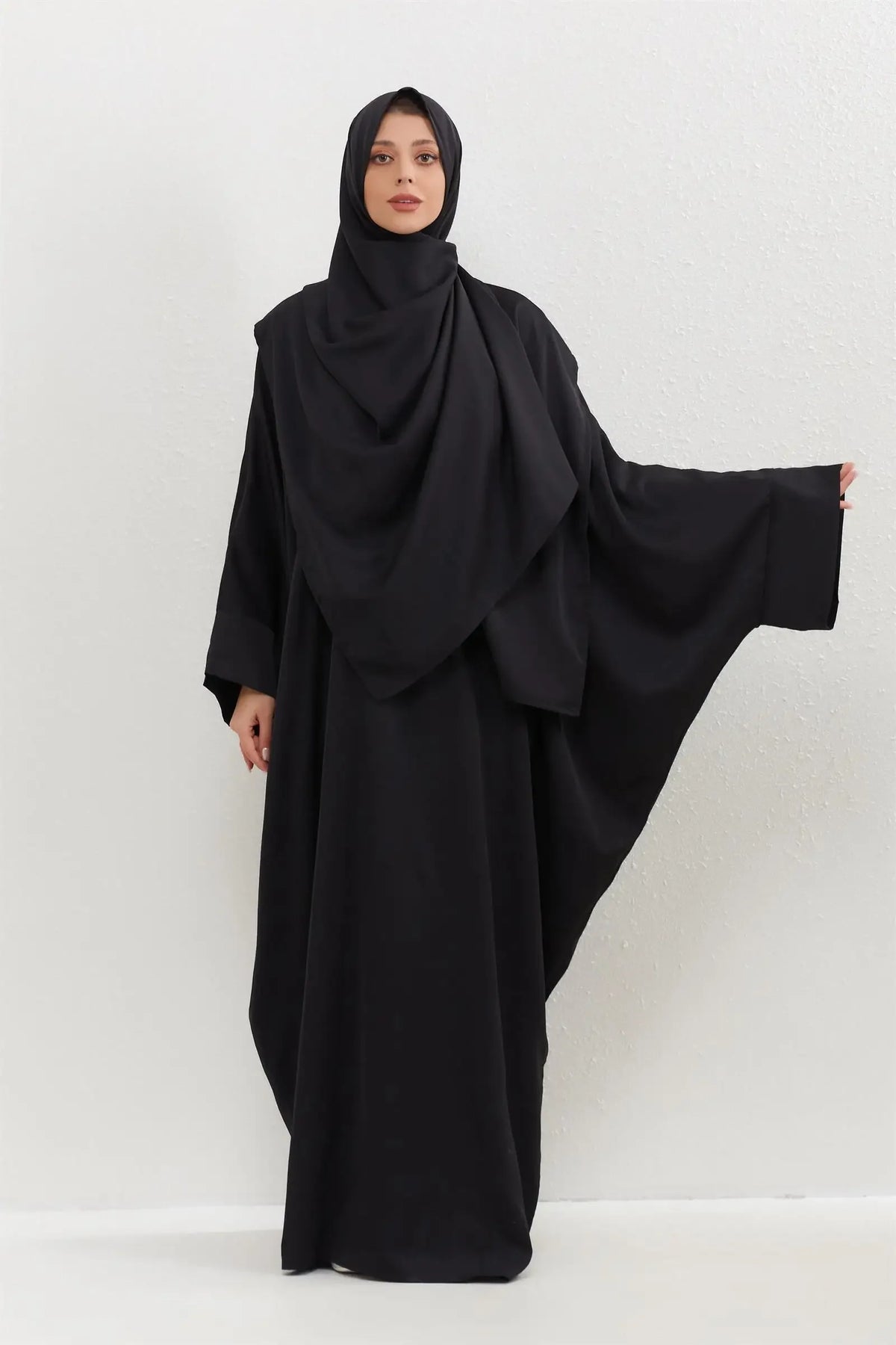 Eine Frau in einem schwarzen traditionellen Hijab-Kleid mit Hijab.