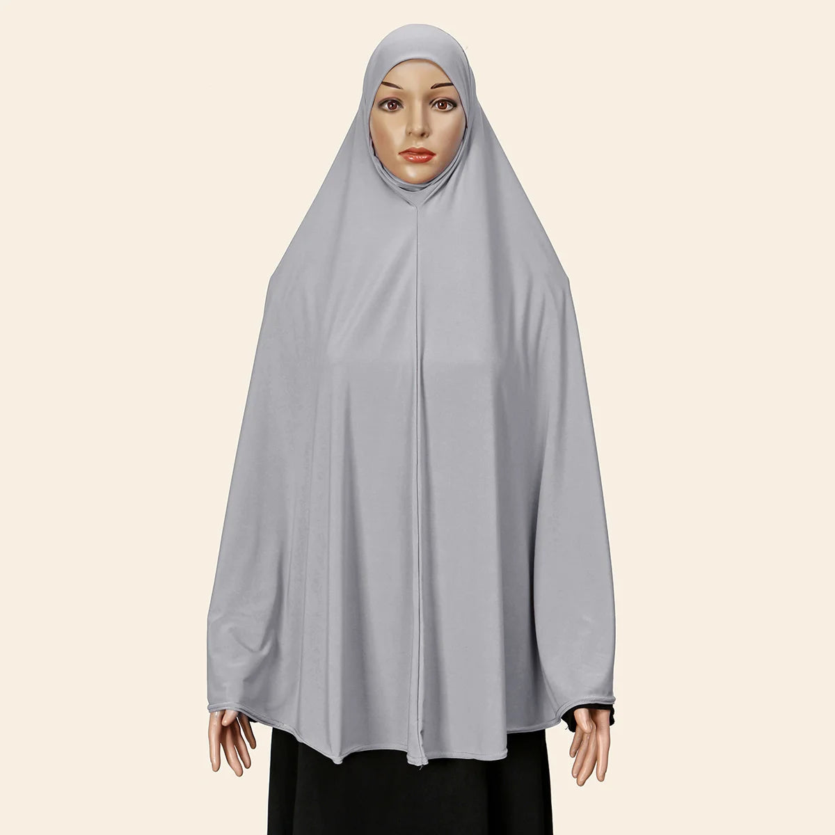 Eine Frau trägt eine hellgraue, komplett bedeckende Abaya mit innerer Hijab.