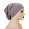 Una modelo lleva un gorro hijab de modal de algodón elástico suave en color malva.
