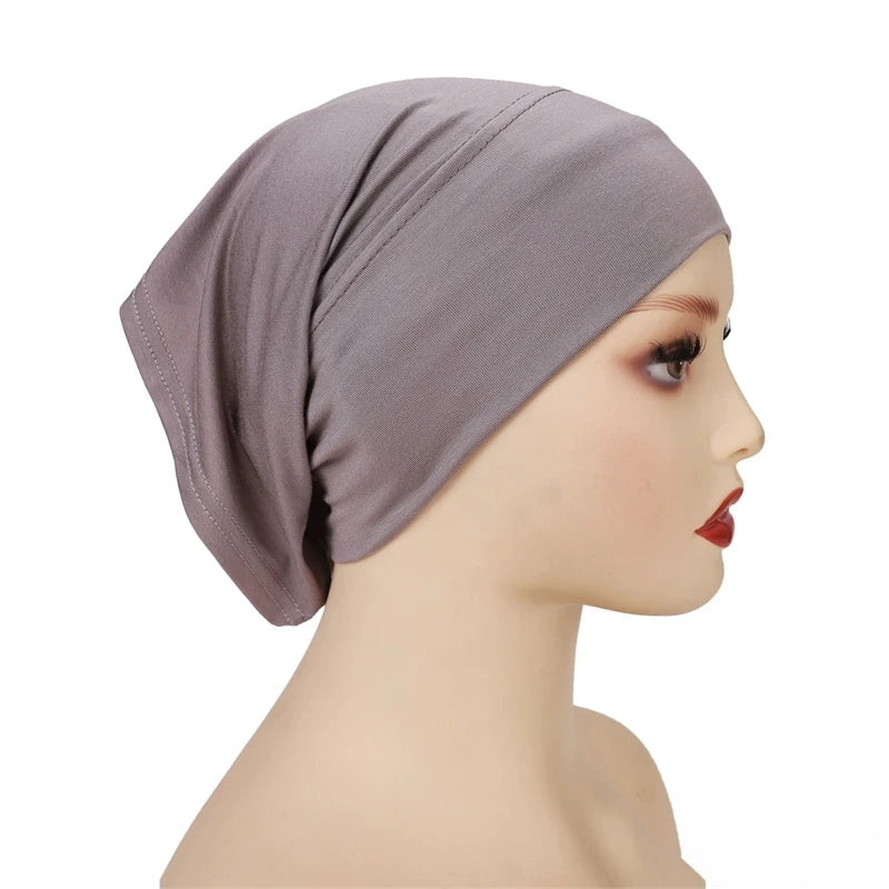 Una modelo lleva un gorro hijab de modal de algodón elástico suave en color malva.
