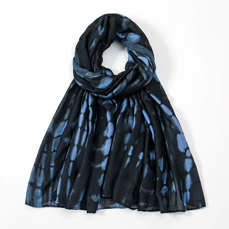 Dunkelblaue und schwarze aquarellierte Schalmuster, um den Hals drapiert.