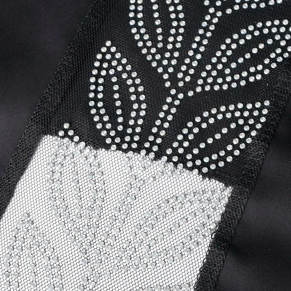 Primer plano de una elegante abaya negra con bordado de ojales blancos y un patrón de hoja.