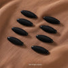 Set of 8 black brooch pins displayed on a textured brown fabric.
