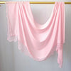 Hijab de encaje rosa doble cara colgado en un perchero de madera.
