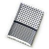 hiyab keffiyeh de gasa blanca y azul marino, doblada para exhibición.