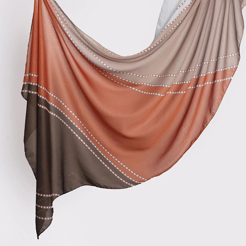Fließender, durchscheinender Schal oder Hijab mit Aquarell-Blumenmuster in Pfirsich- und Brauntönen.