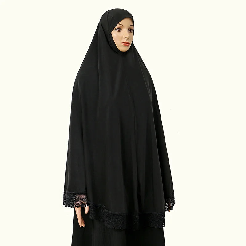 Eine Frau trägt einen schwarzen, voll bedeckenden Instant-Hijab mit Spitzenrand.