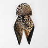 Pañuelo de satén negro y estampado de leopardo atado en estilo turbante para el cabello.
