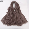Un foulard hijab de viscose brun doux drapé et plié sur un fond blanc.