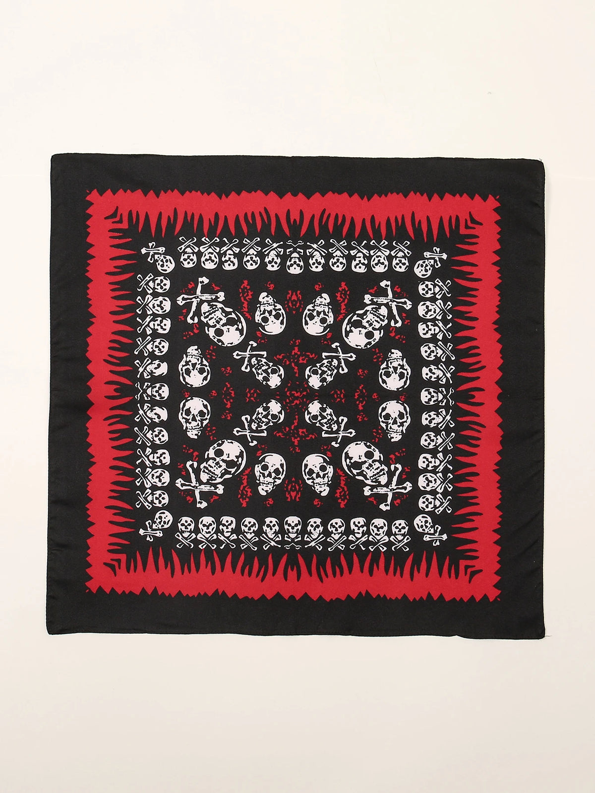 Carré de tissu noir avec un motif répétitif de crânes et d'os blancs sur fond rouge.