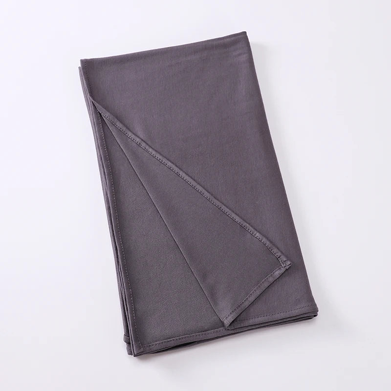Foulard instant stretchy en jersey gris foncé plié.