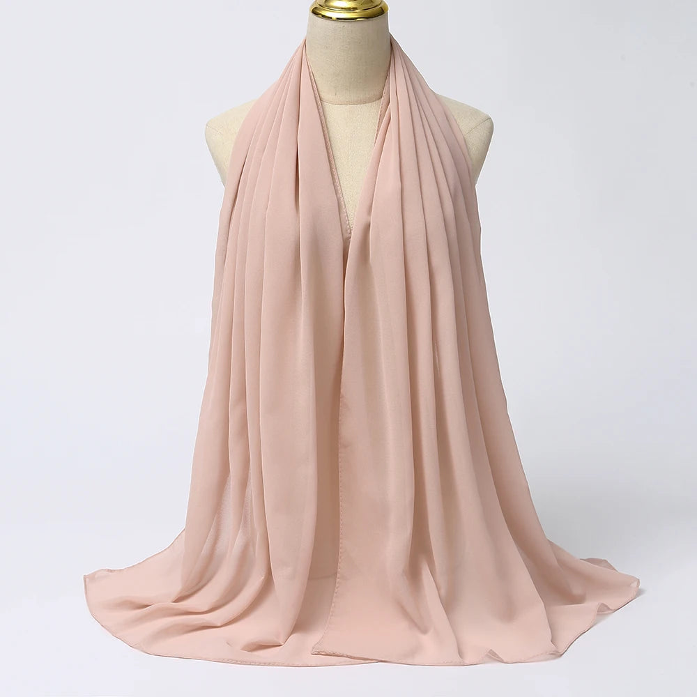 Ein zartes blassrosa Chiffon-Hijab-Tuch, um den Hals einer Mannequin drapiert.