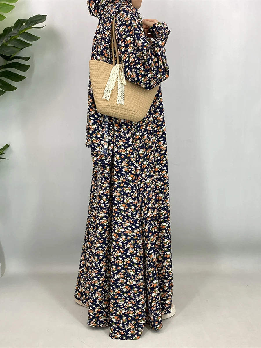 Una mujer vistiendo una elegante kaftan abaya floral con mangas largas y un bolso de hombro tejido beige.