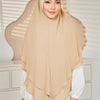 Eine Frau trägt einen beige-beigen doppelten Chiffon-Instant-Hijab-Schal mit einem weißen Oberteil.