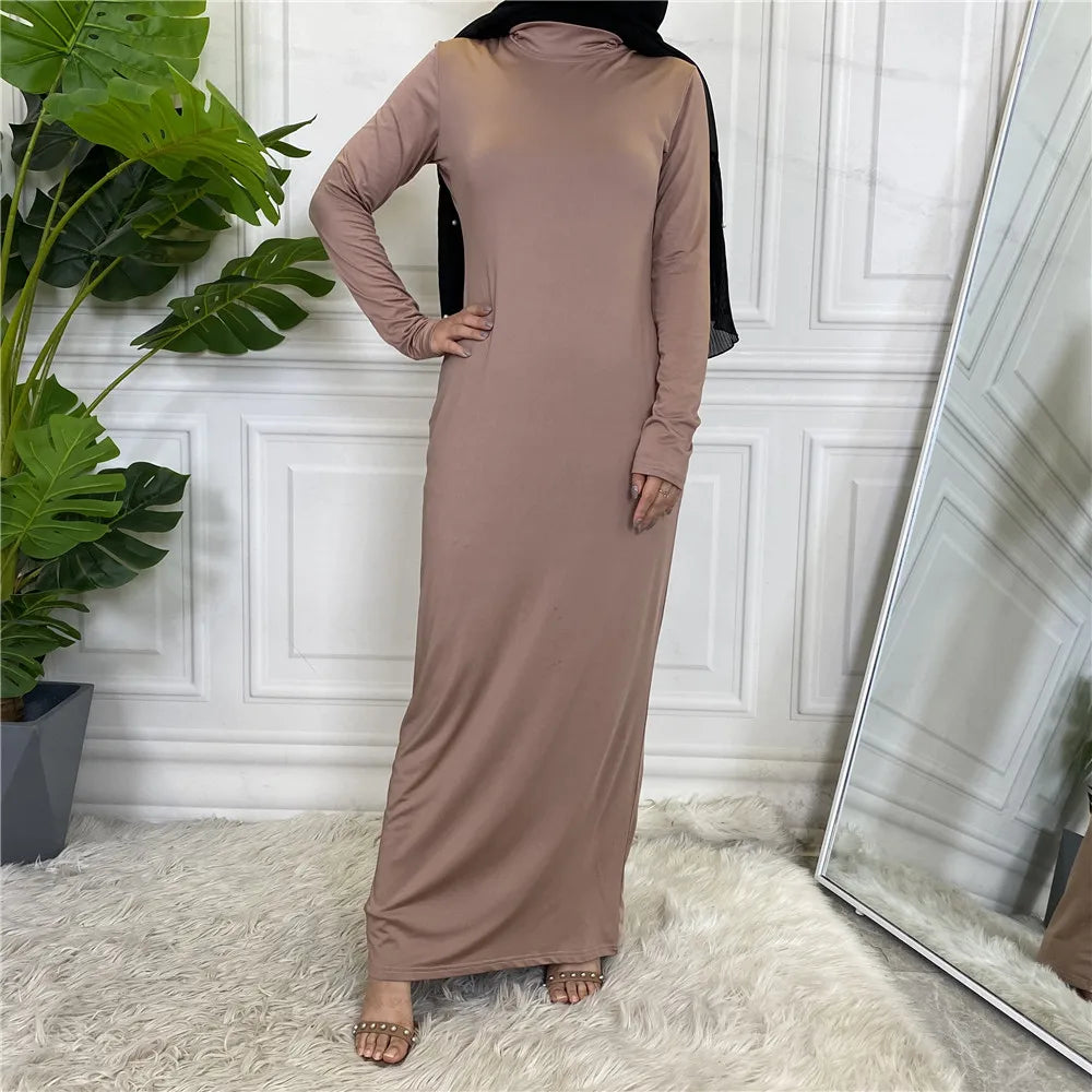 Langes, mauvefarbenes Abaya-Kleid mit langen Ärmeln, getragen von einem Model in einem hellen Raum.