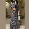 Une femme porte un long trench à motif plissé avec une doublure bleu foncé.