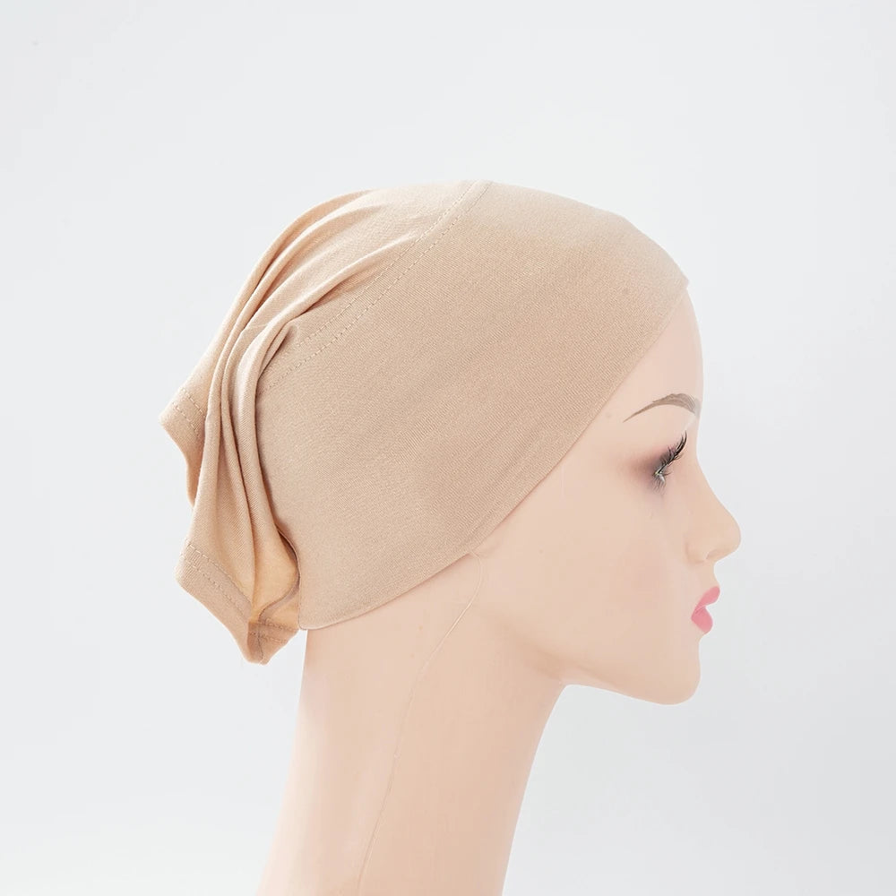 Beige Bambus-Jersey-Turbanmütze, drapiert auf einem Mannequin-Kopf.