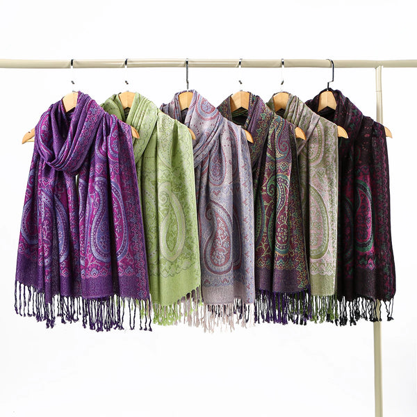 A display of vintage paisley embroidery shawl scarves hanging on a wooden rack.