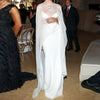 A woman wearing an elegant sheer mesh poncho cape for evening wear stands indoors.