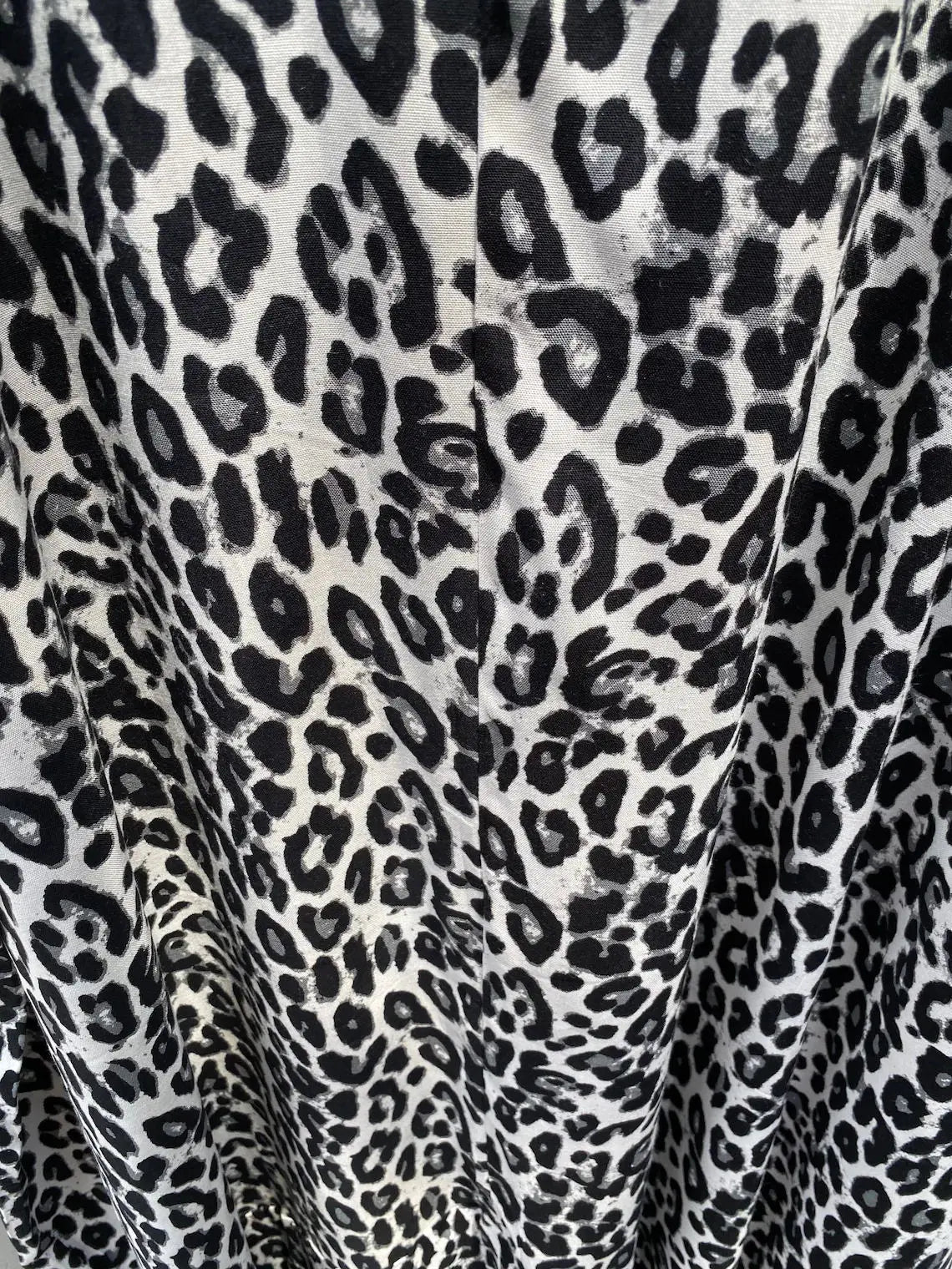 Nahaufnahme eines schwarz-weißen Leopardenmusterstoffes, wahrscheinlich ein Sommer-Strandkimono-Kleid.